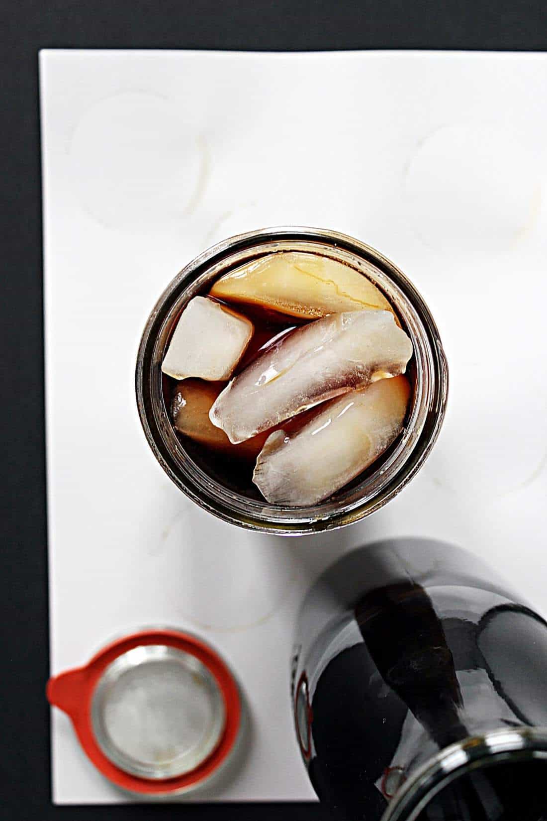 Overhead view looking into a jar with coffee and ice cubes.