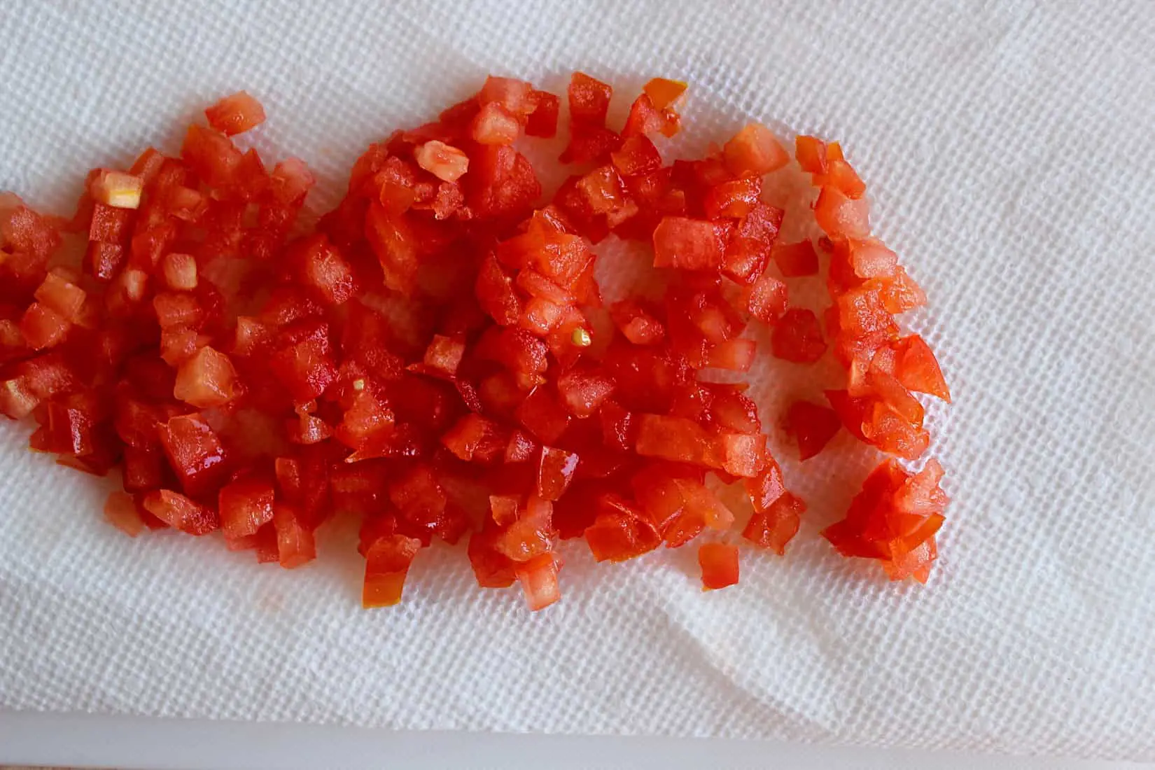 Deseeded and diced tomatoes on a paper towel.