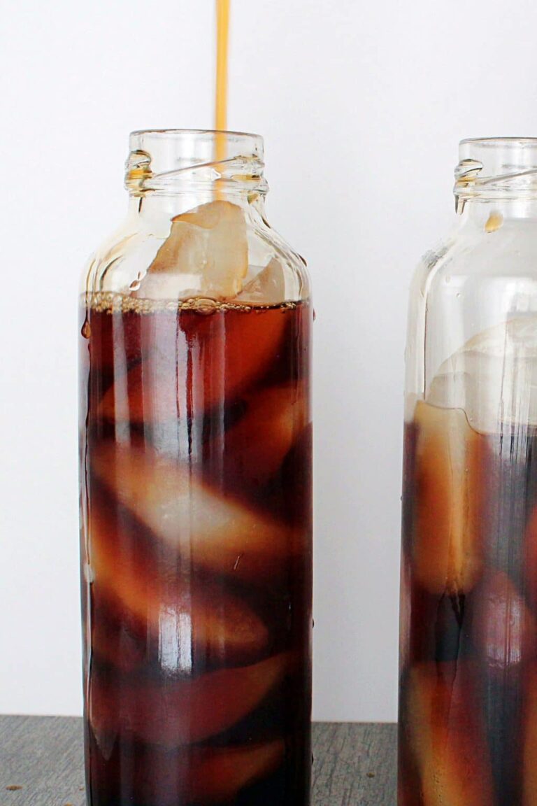 Pouring iced tea into a bottle filled with ice