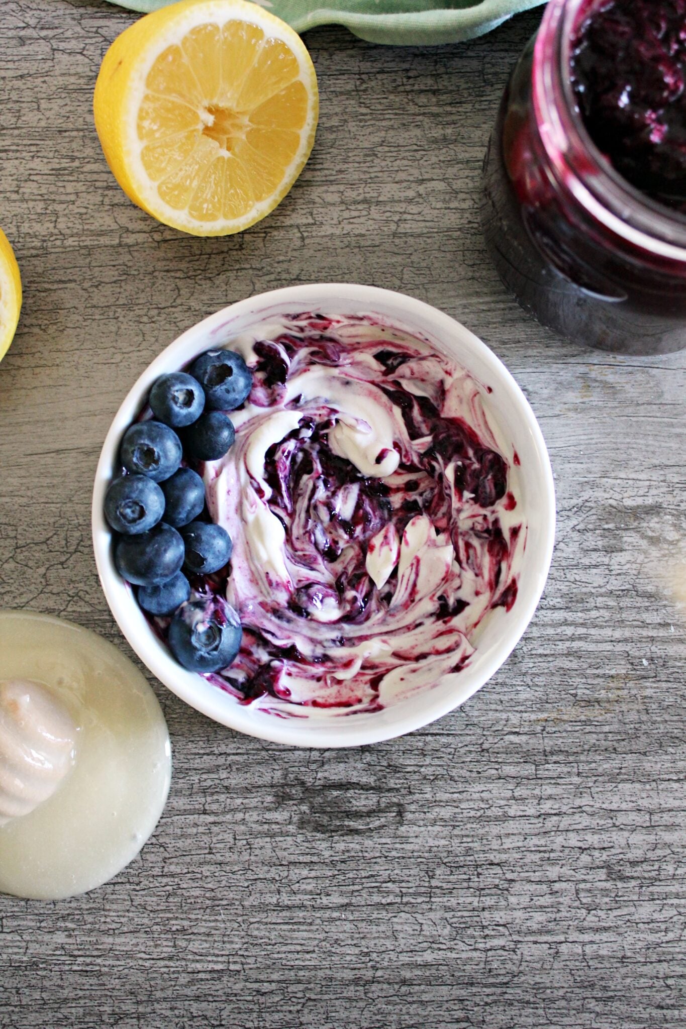 Instant pot blueberry jam swirled into a white dish with white yogurt.