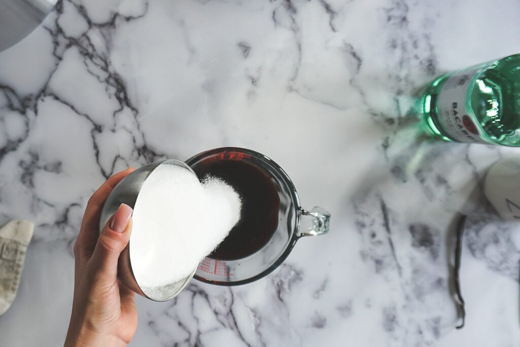 Pouring sugar into the hot coffee.