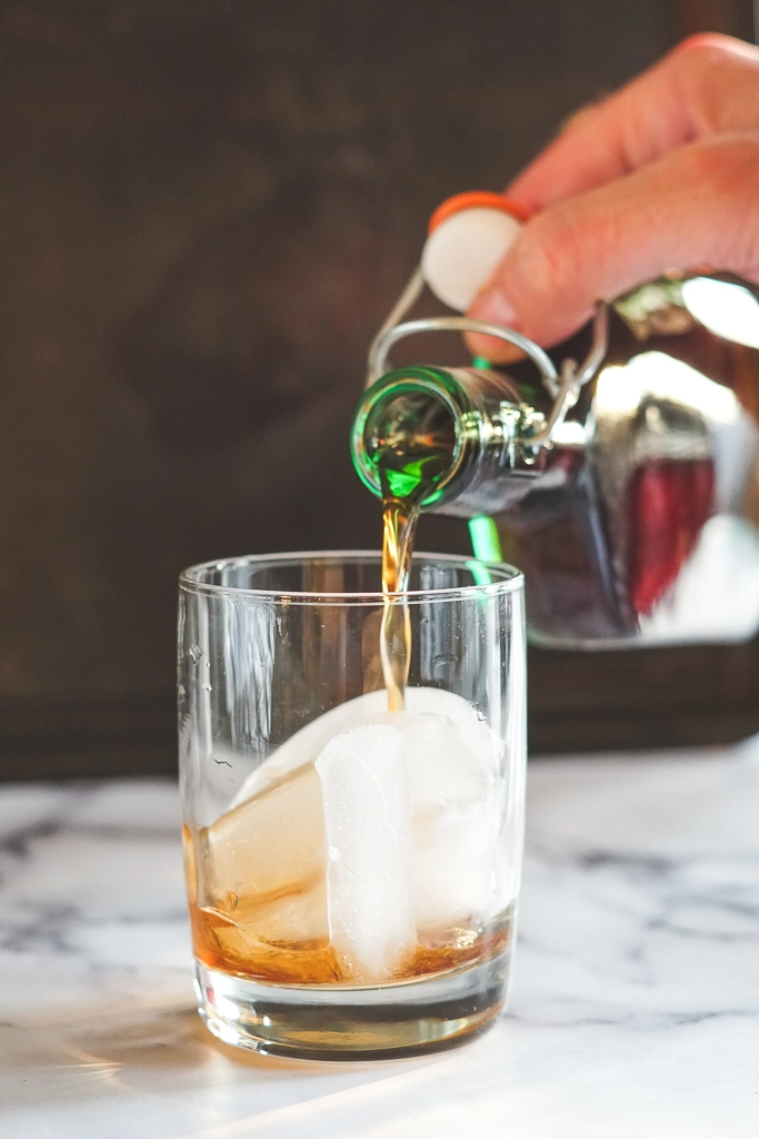 Pouring sous vide Kaluha into a glass with ice.
