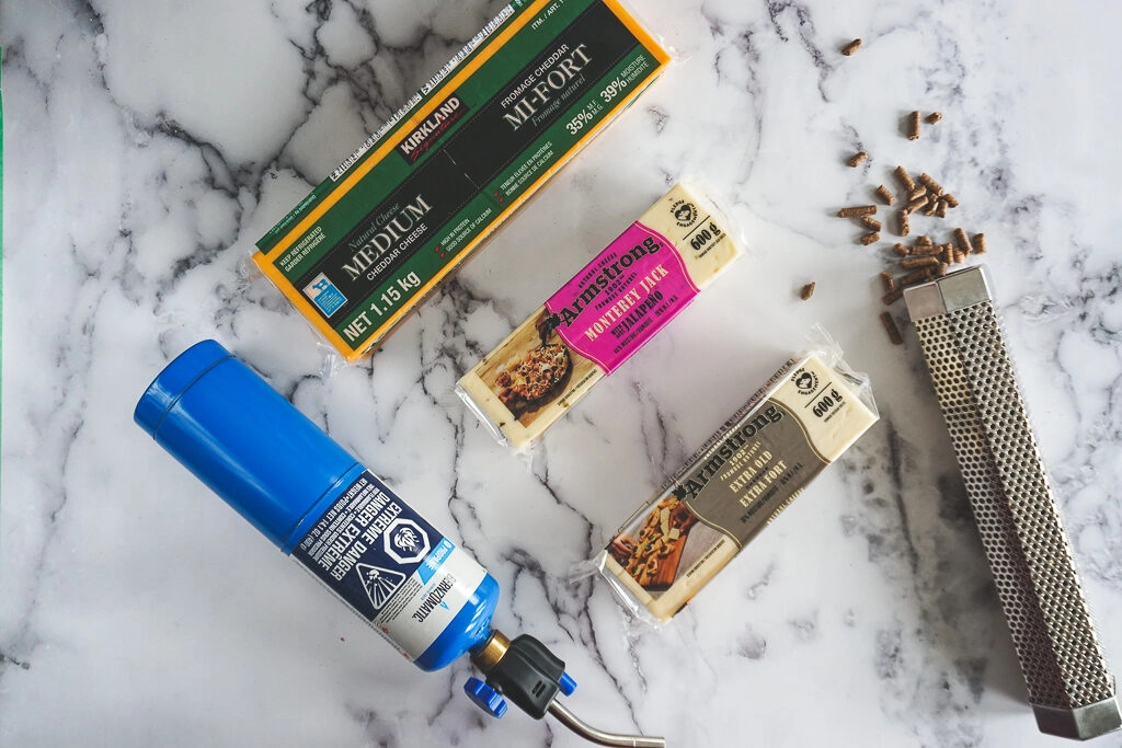 A collection of cheeses and a smoke tube before smoking.