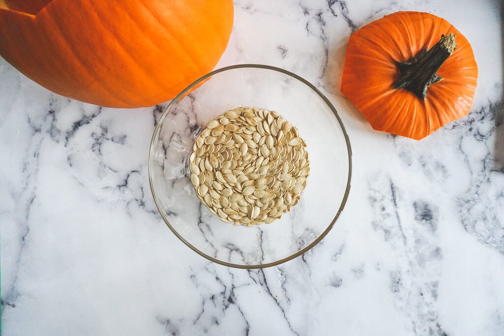 pumpkin seeds soaking in a glass bowl.