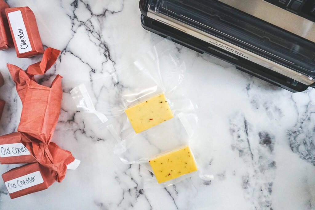 Smoked cheese wrapped in butchers' paper with some smoked cheese that has been vacuum sealed.