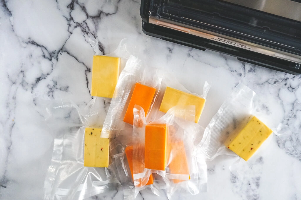 Blocks of smoked cheese piled up after being vacuum sealed.