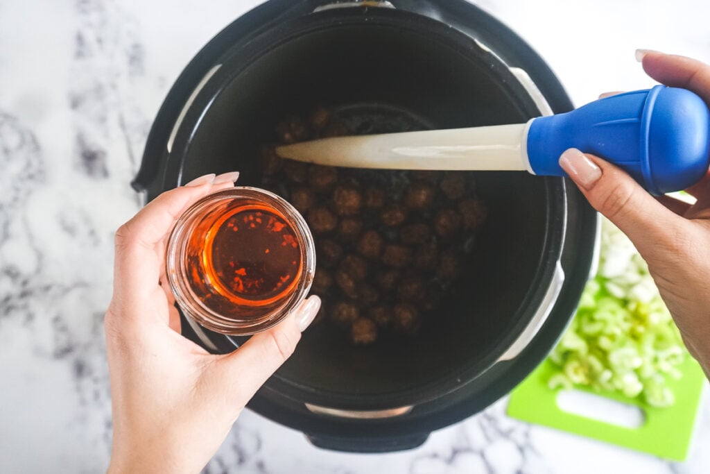 Using a turkey baster to remove the fat from the Instant Pot. 