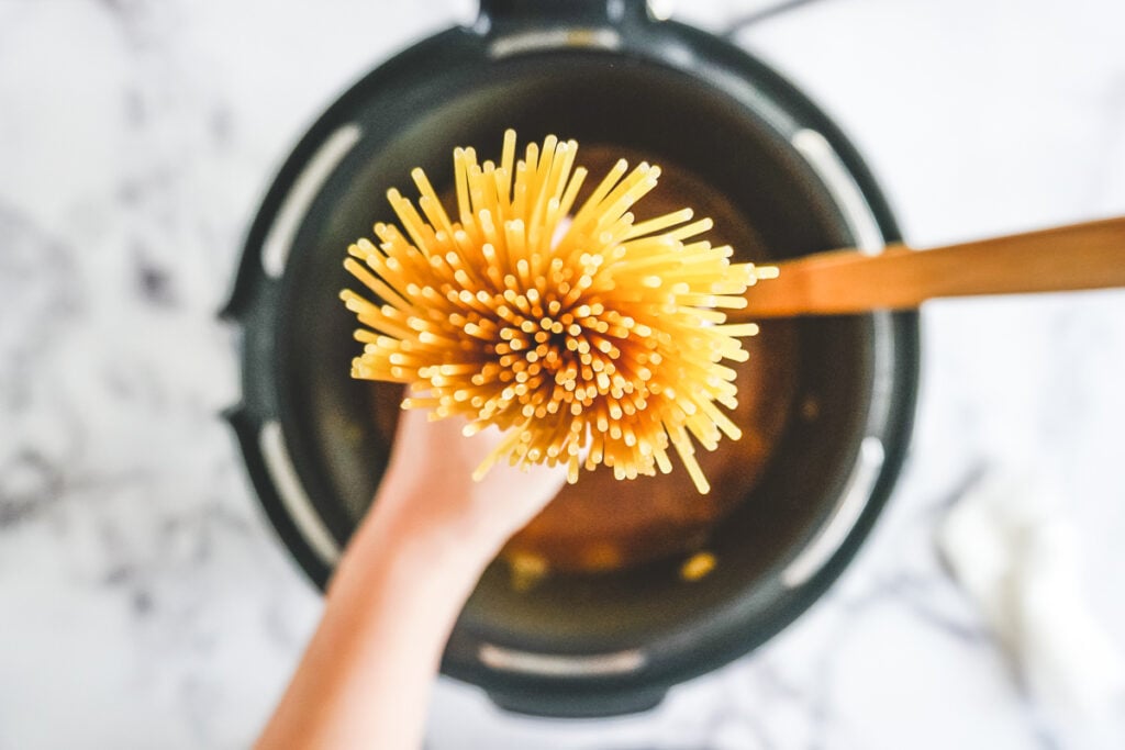 Hands holding a bouquet of spaghetti. 