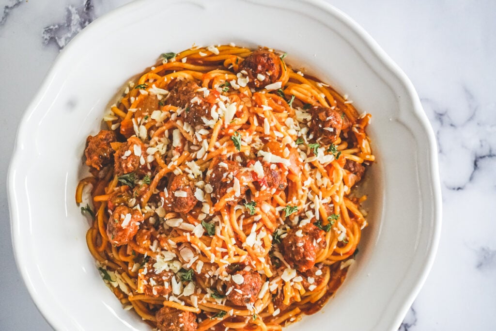 A bowl of instant pot spaghetti topped with shredded parmesean.