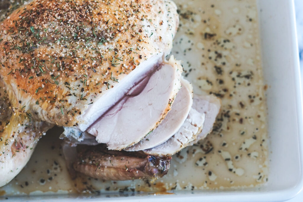 Cooked chicken with the breast sliced.