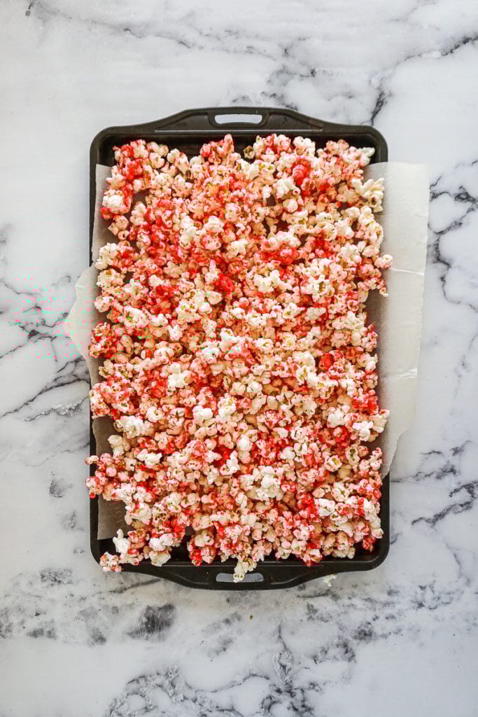 Strawberry flavoured popcorn on a cookie sheet.