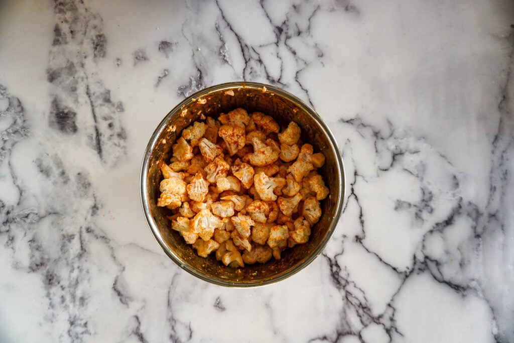 Fresh cauliflower tossed in the orangey maple sriracha sauce before being air fried.