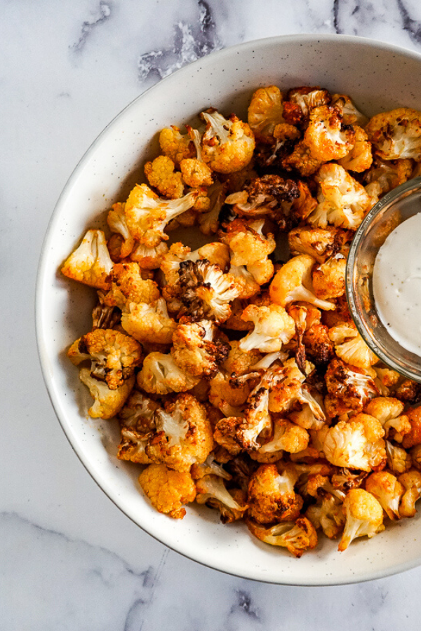 Close up view of a bowl of air fried cauliflower.