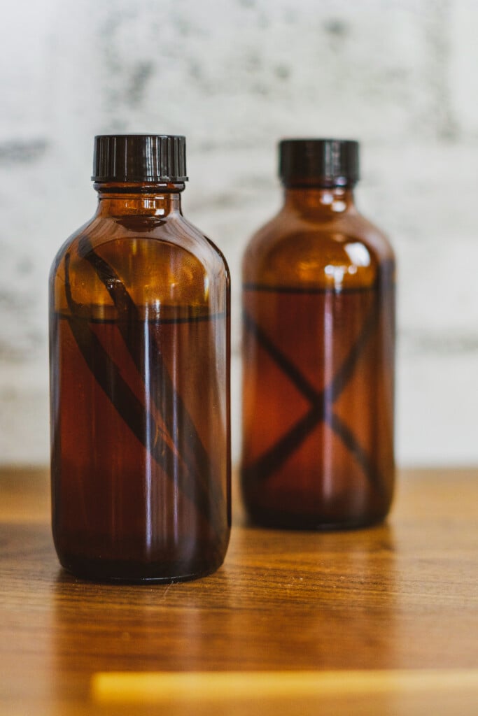 Sous vide vanilla extract with vanilla beans in the amber jar.