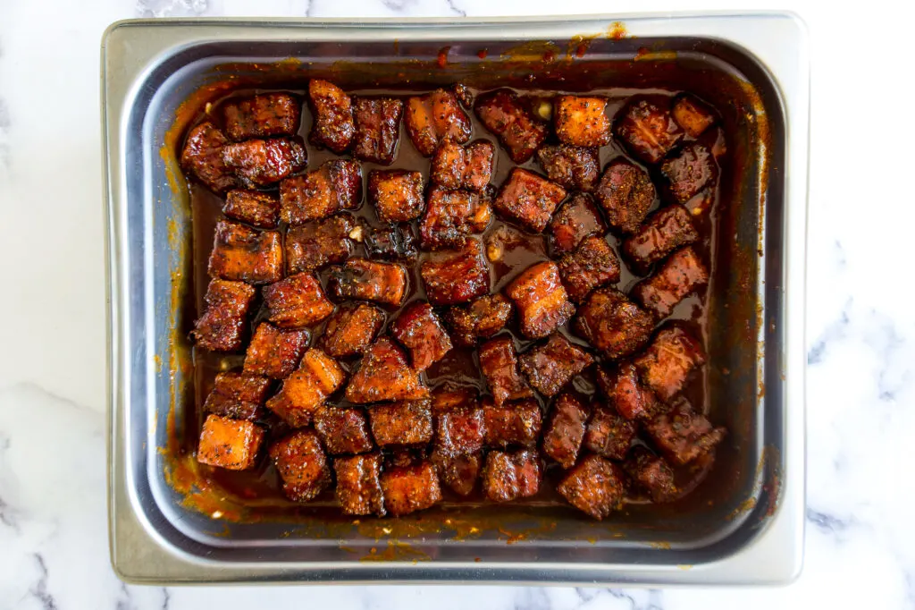 Pork belly cubes in the sauce before cooking.