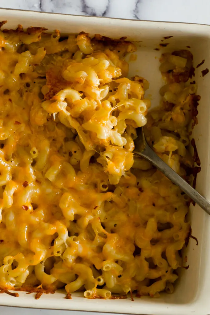 Melted cheesy mac and cheese being stirred.