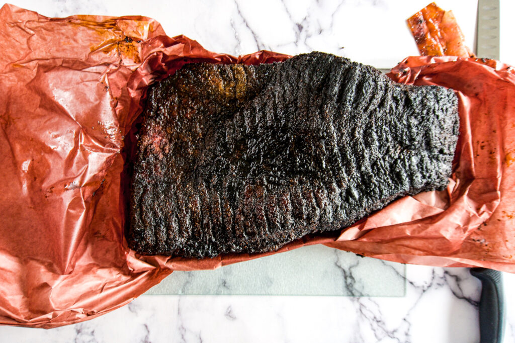 Fully opened up butchers paper shwoing off a dark smoked brisket
