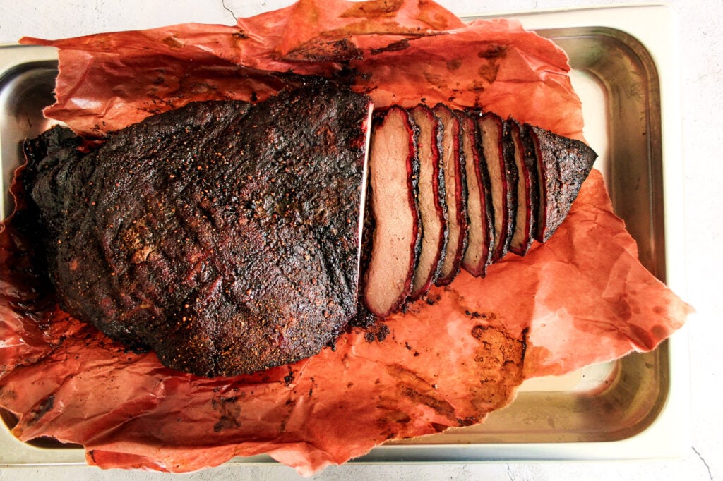 smoked brisket wrapped in butcher paper in a chafing pan.