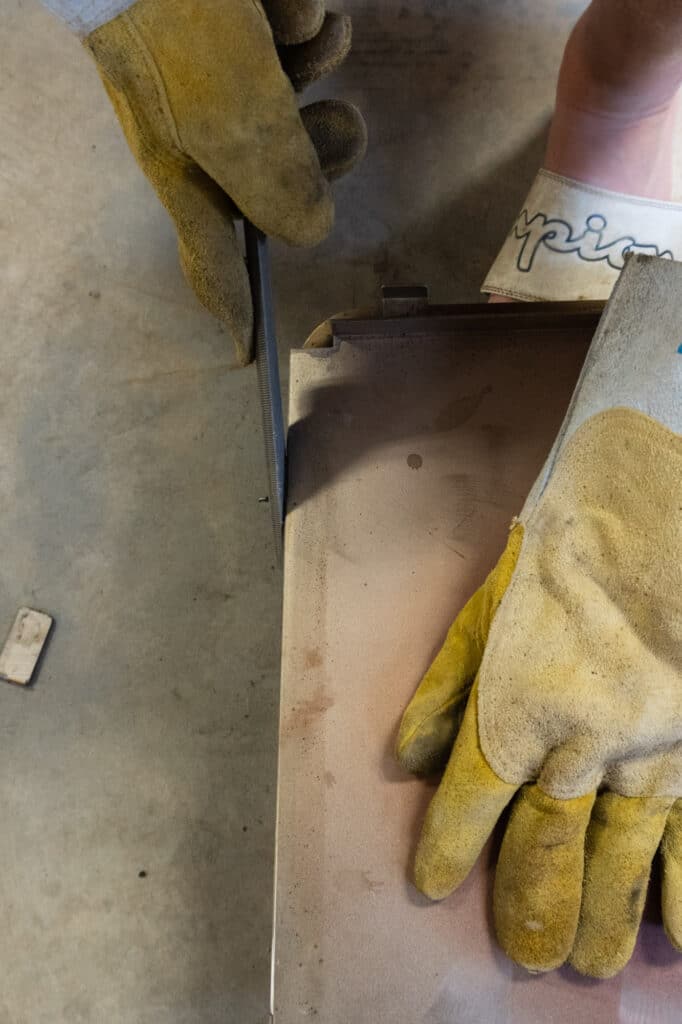 Filing the excess steel with a half round bastard file.