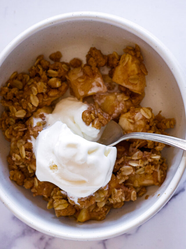 A bowl of apple crisp with ice cream