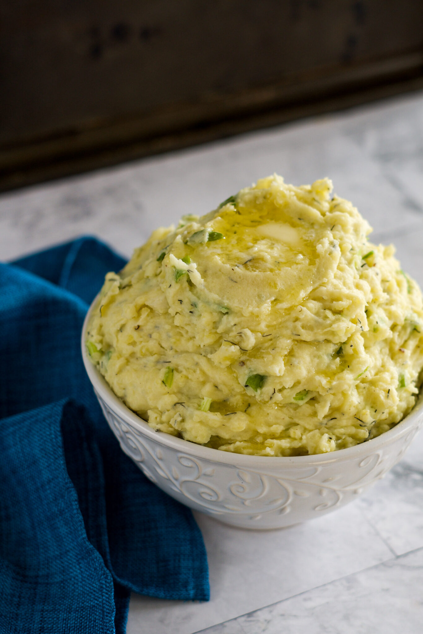 Creamy sous vide mashed potatoes with melting butter dripping down the side.