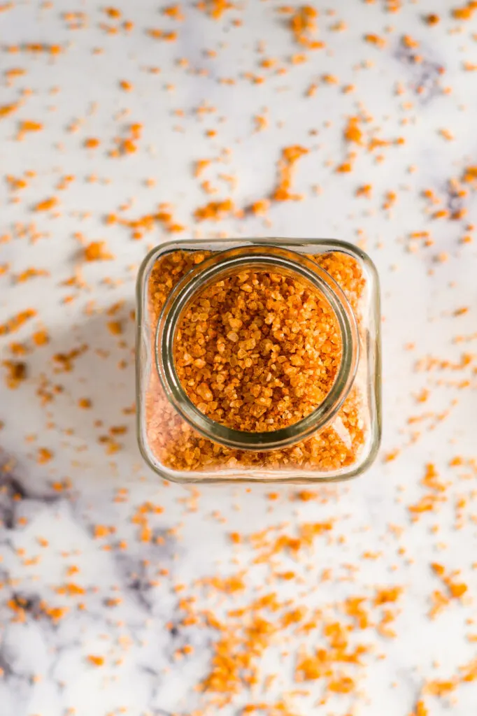 Overhead view of a glass jar of sriracha salt.