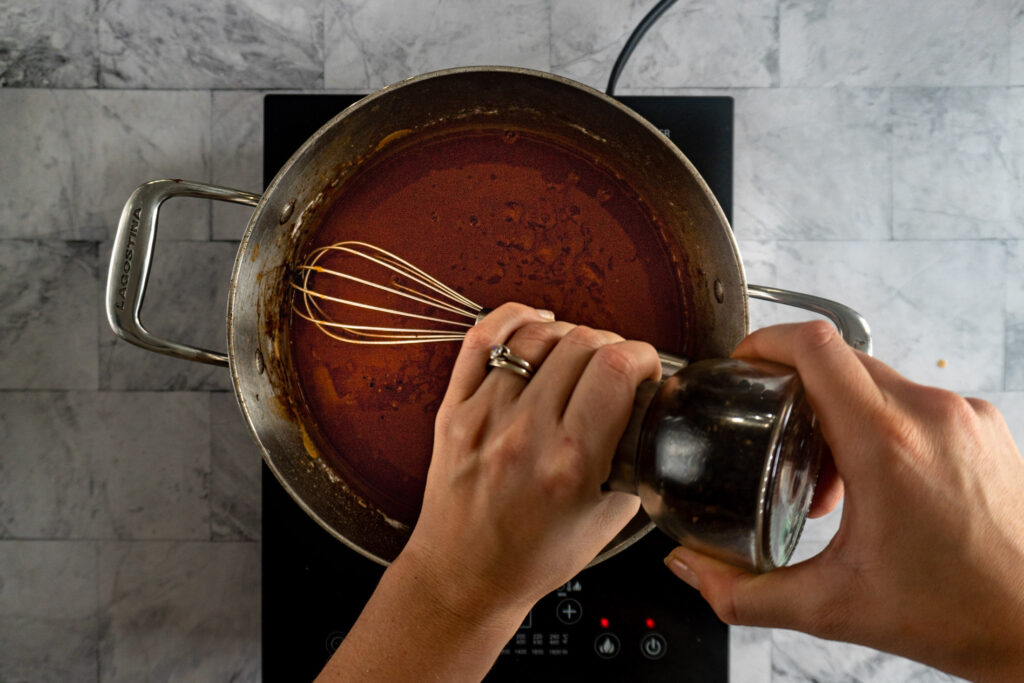 adding ground pepper to the gravy.