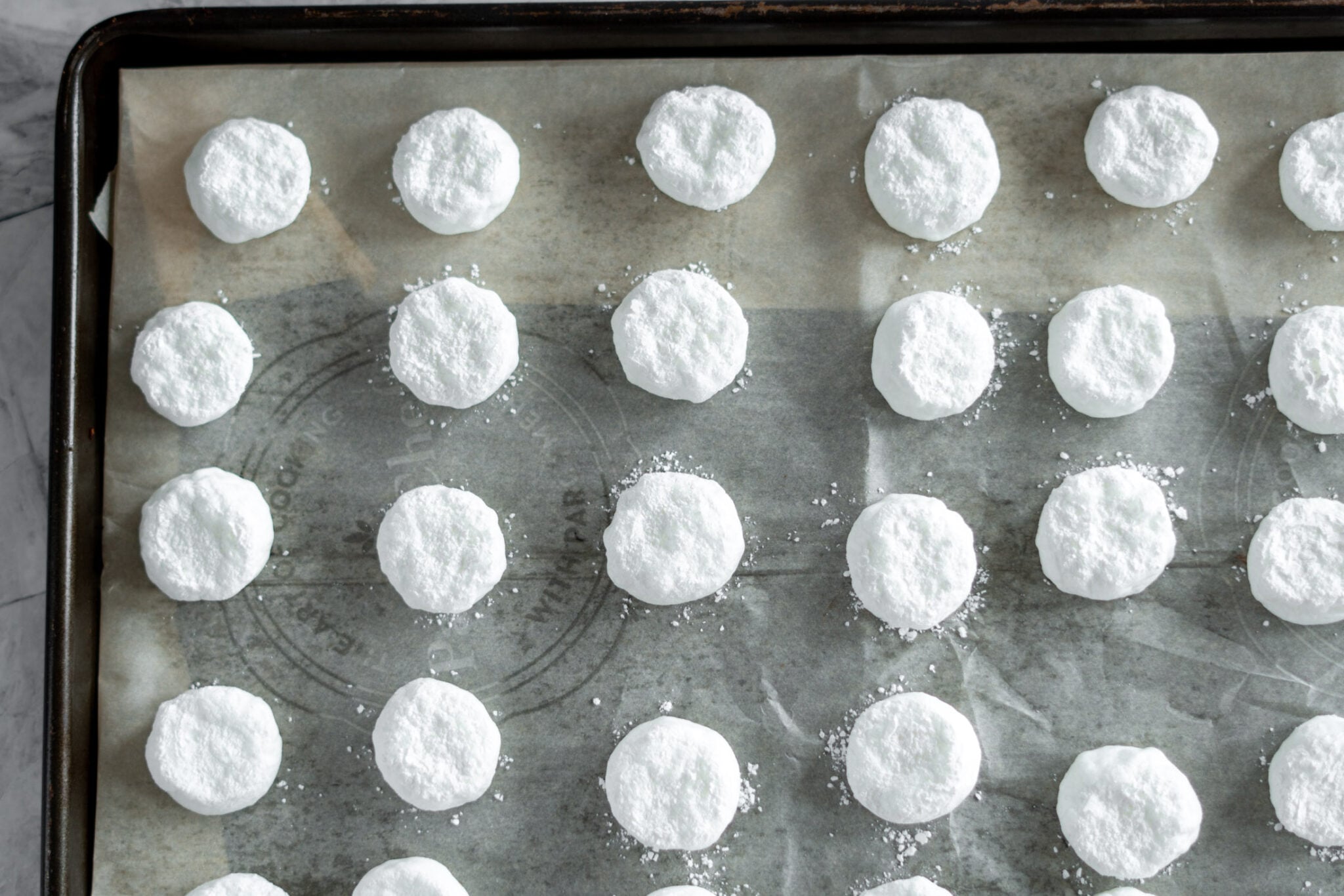 Full sized marshmallows on a baking sheet. 