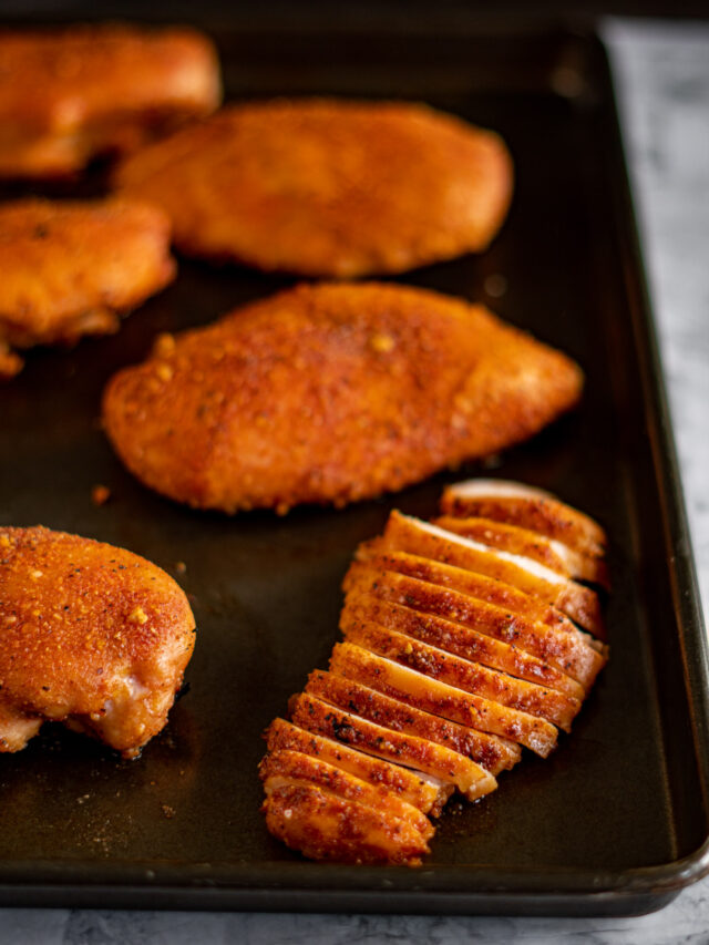 Sliced smoked chicken breast on a baking sheet.