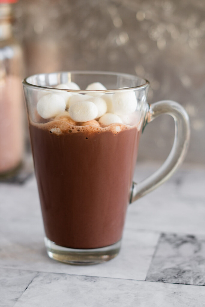Hot chocolate in a tall mug topped with marshmallows.
