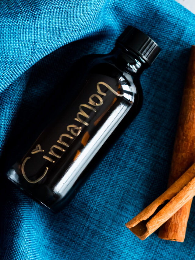 An amber bottle filled with cinnamon extract on a blue napkin.