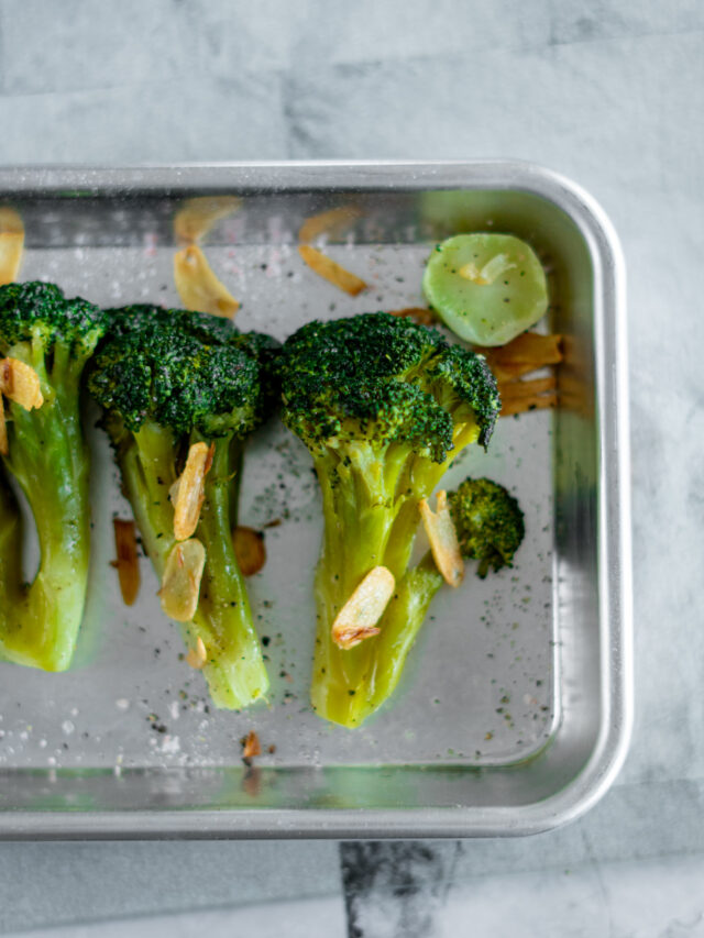 Sous vide broccoli in a mini sheet pan topped with browned garlic