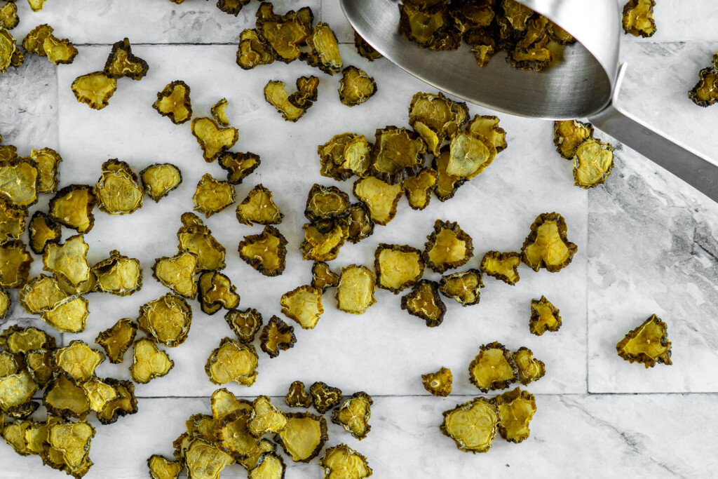 Dehydrated pickles spilling out of a measuring cup.