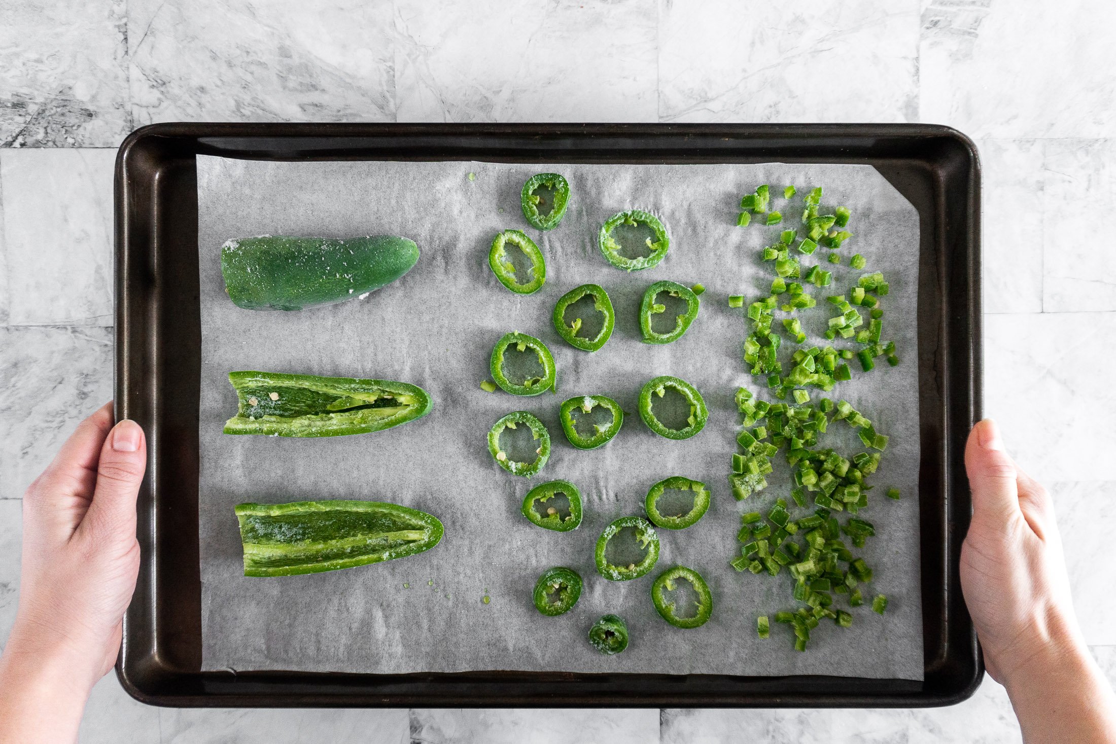 Holding a tray of frozen jalapeno peppers.
