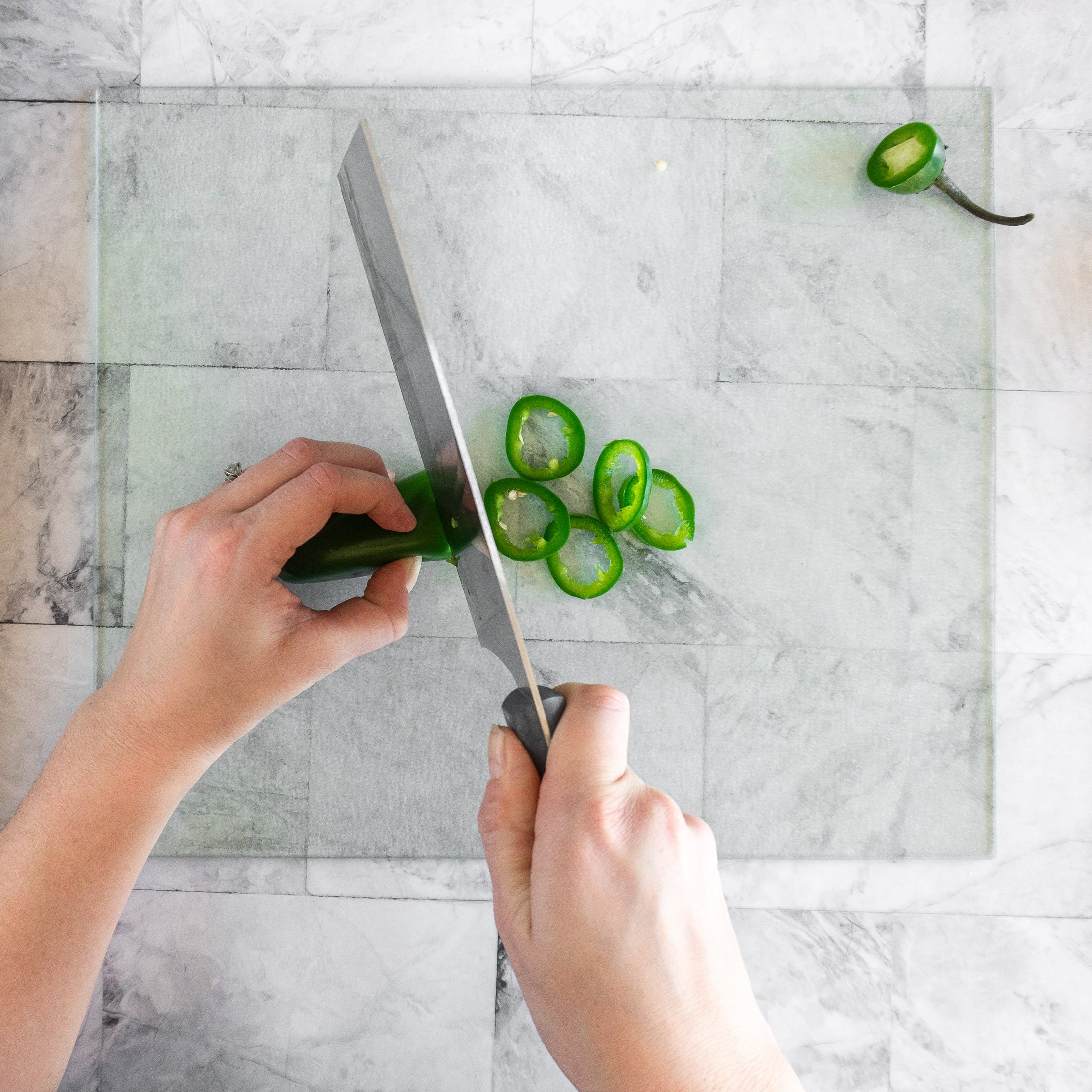 Slicing a jalapeno into rings. 