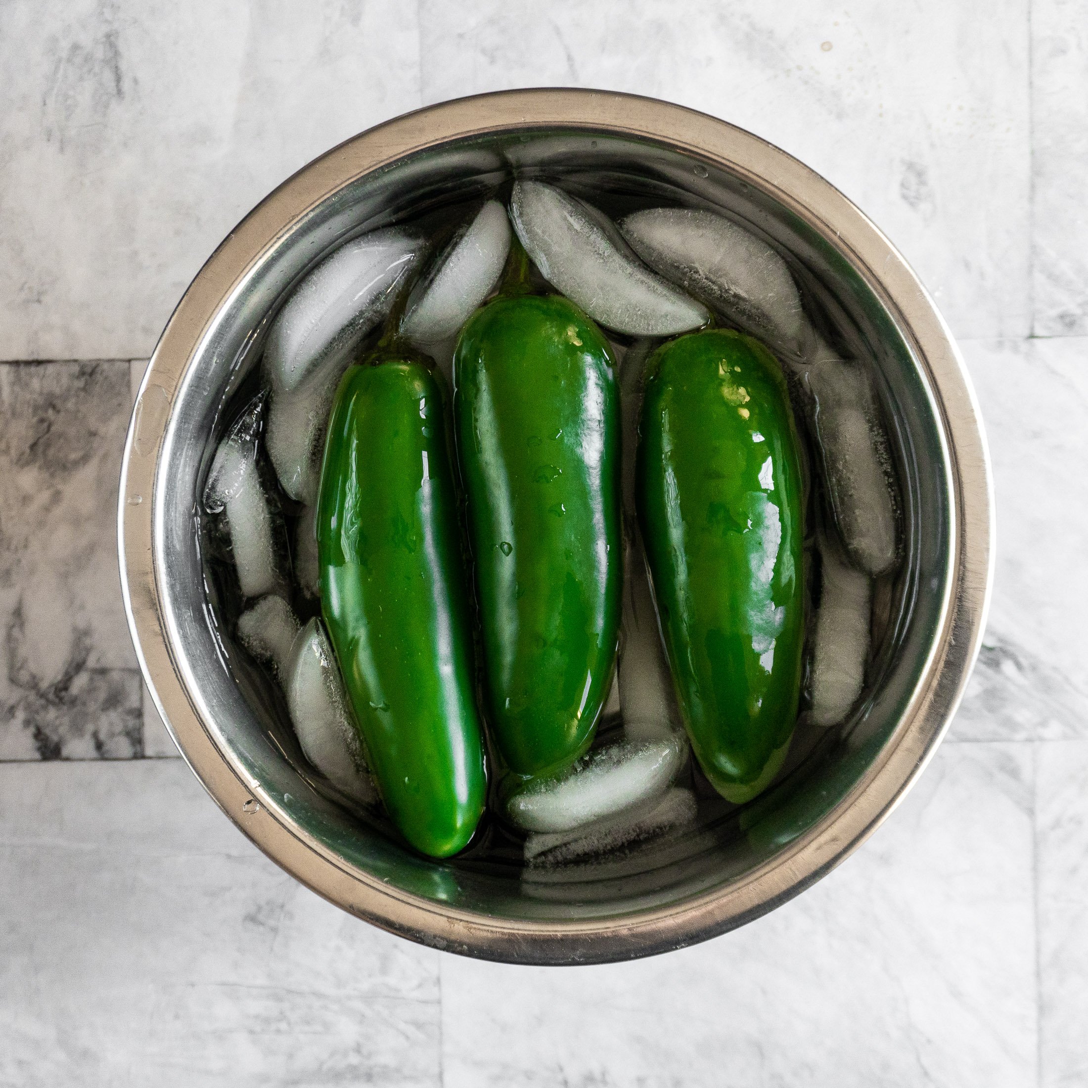 3 jalapenos in a small bowl with ice water. 