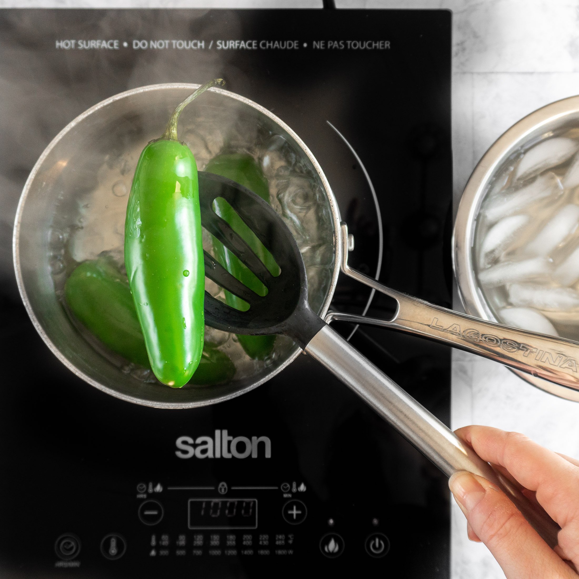 Scooping out a jalapeno with a slotted spoon.