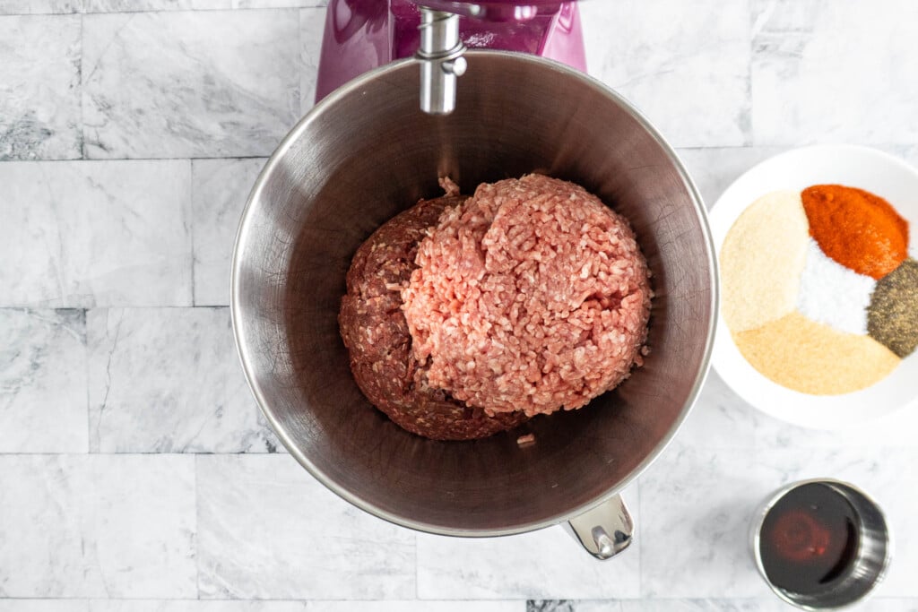 Ground beef and ground pork in the bowl of a stand mixer. 