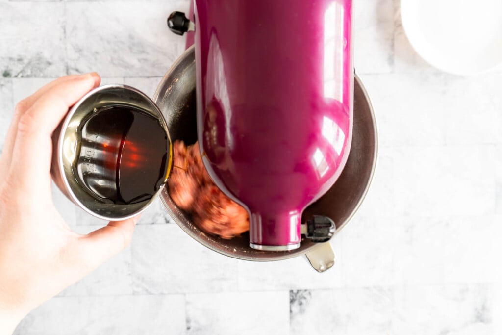 Adding the maple syrup to the stand mixer. 