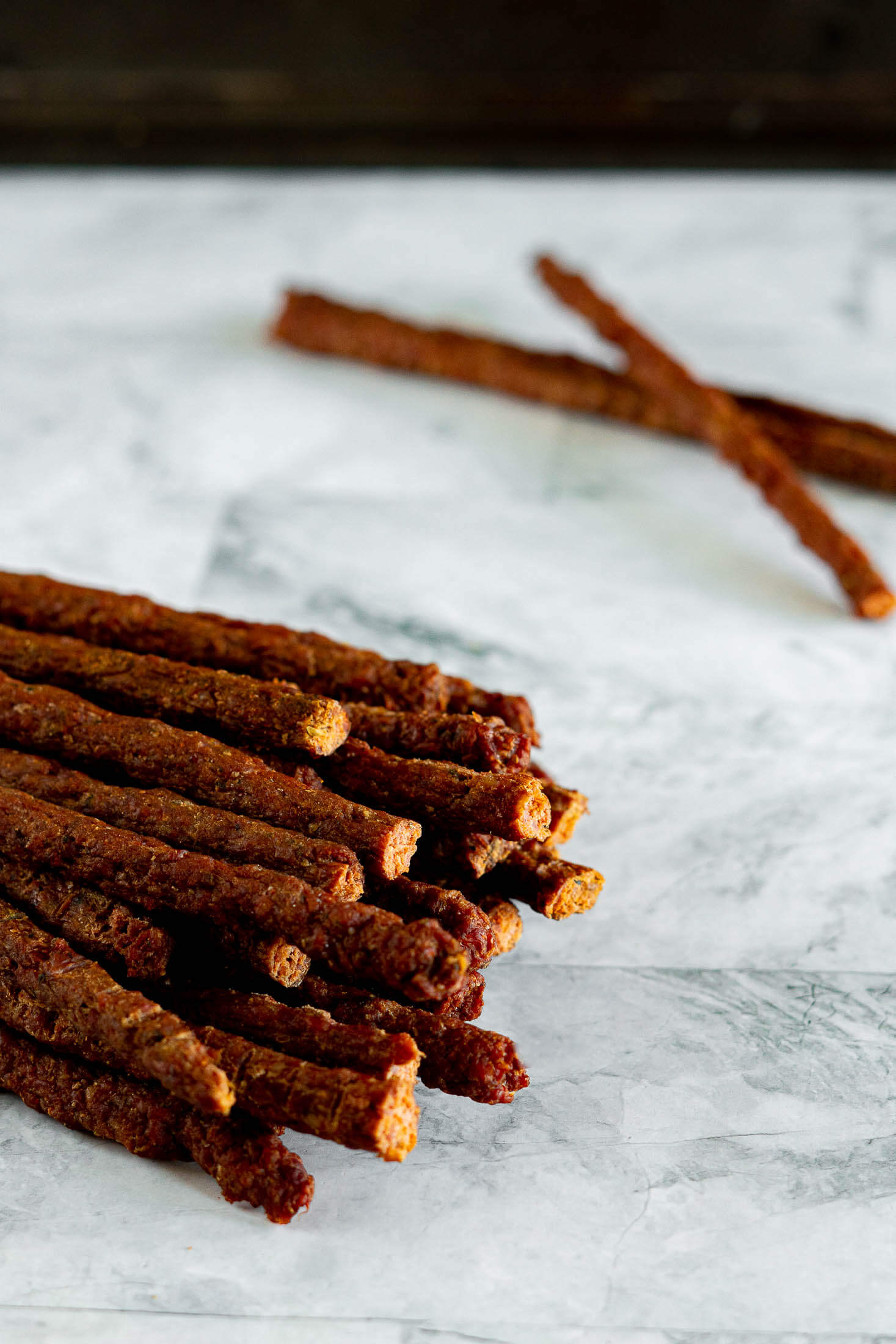 Homemade beef sticks on a marble counter. 