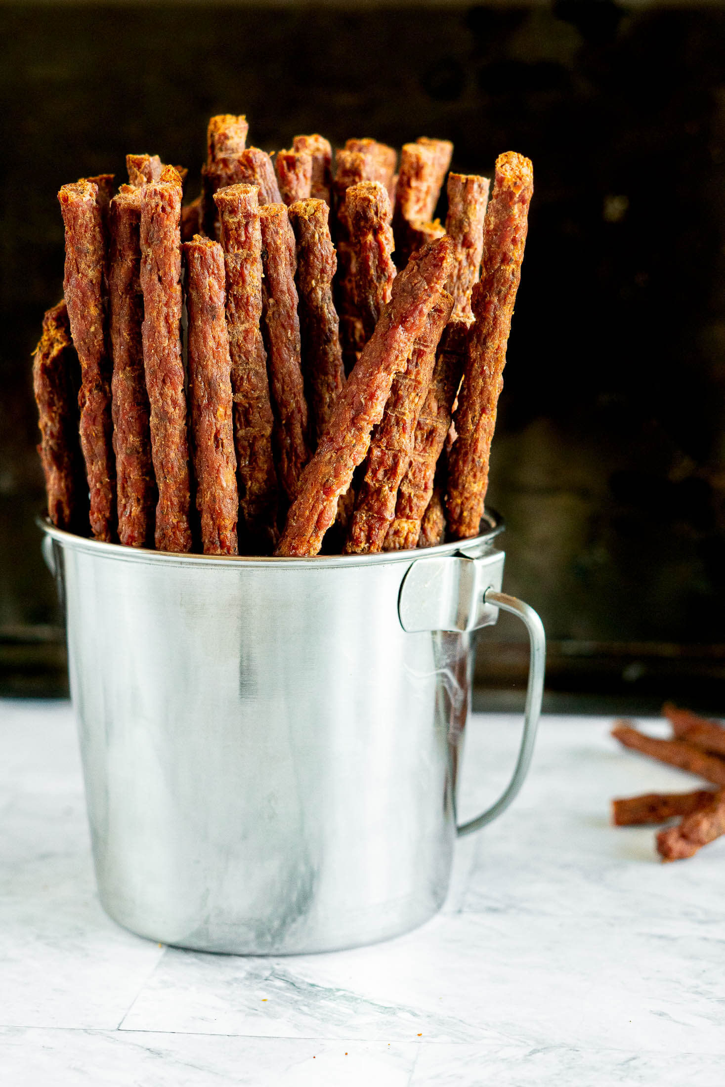 Beef jerky sticks in a tin bucket. 