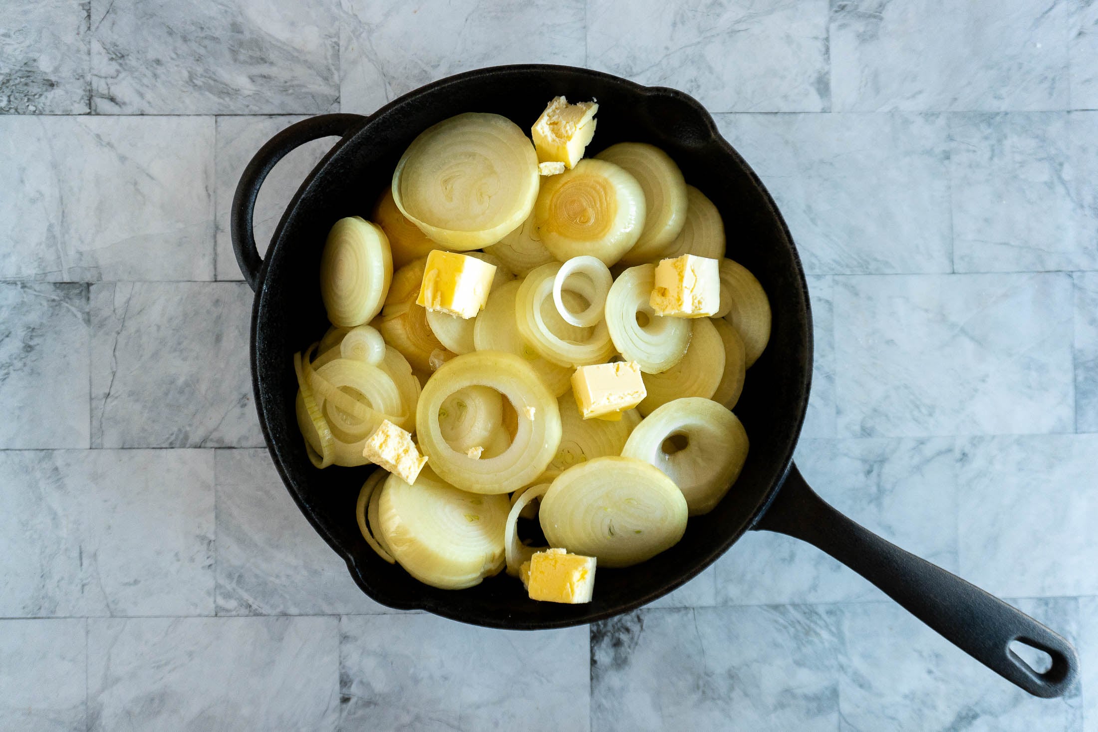 Sliced smoked onions in a skillet.