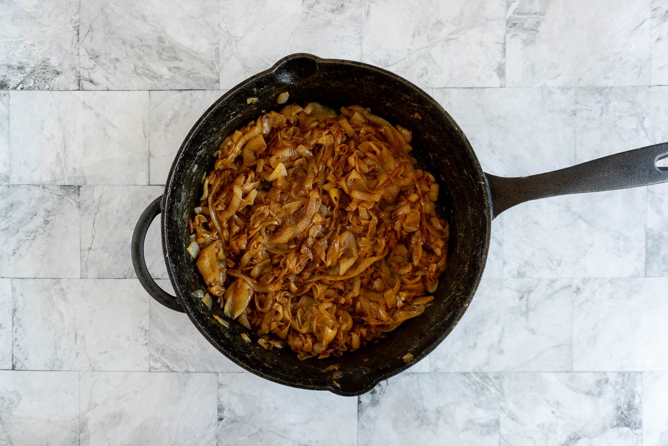 Smoked caramelized onions in a cast iron skillet.