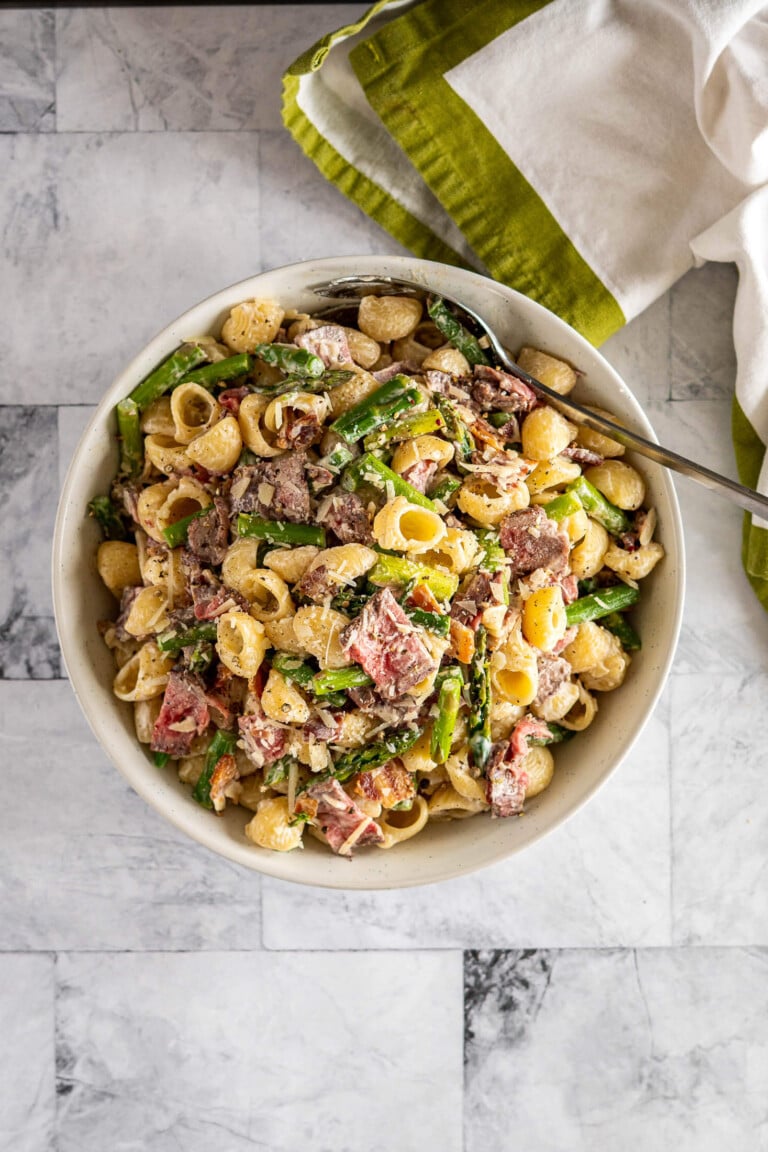 Overhead view of pasta salad with steak in a bowl.