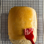 Brushing the sourdough loaf with softened butter.