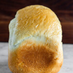 Side view of a loaf of bread machine bread made with sourdough discard.