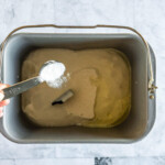 Adding sugar to the bread pan.