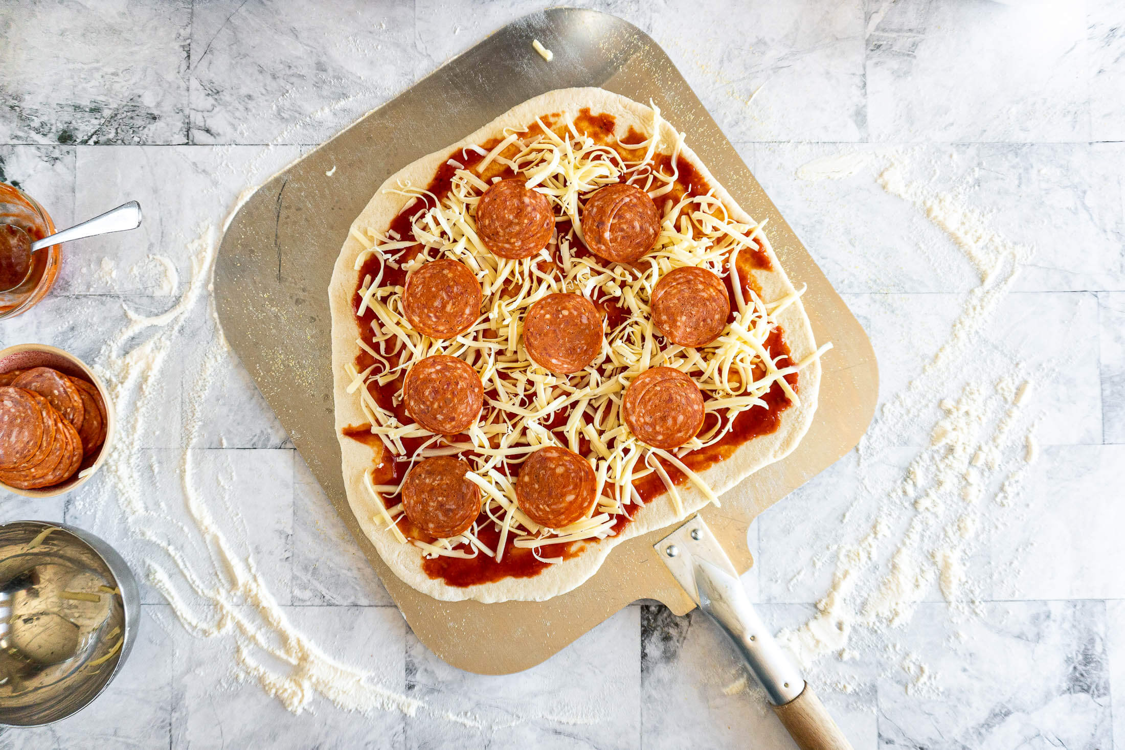 Fully prepared pizza on the pizza peel.