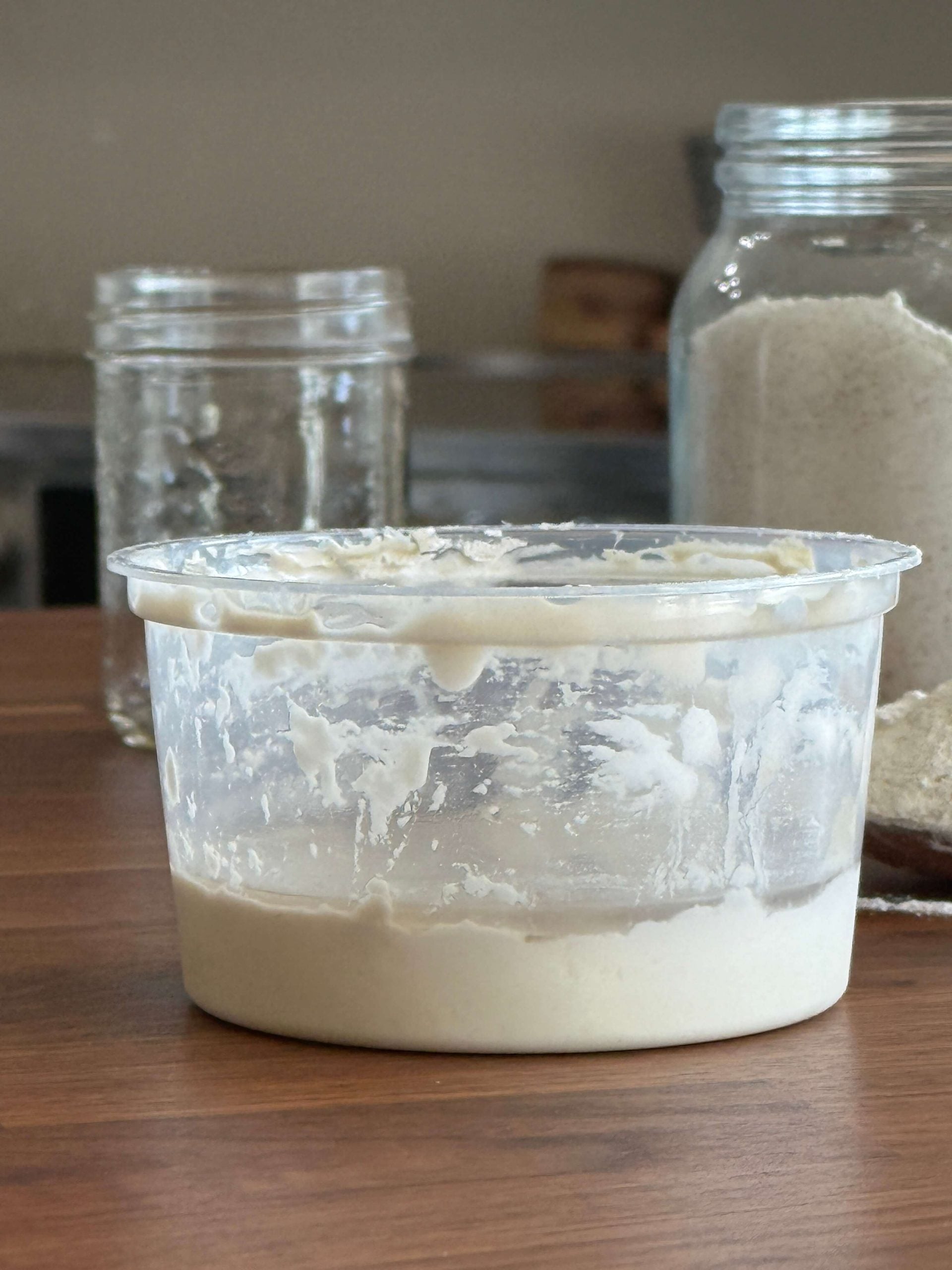 Unfed, neglected sourdough starter warming after leaving the fridge.