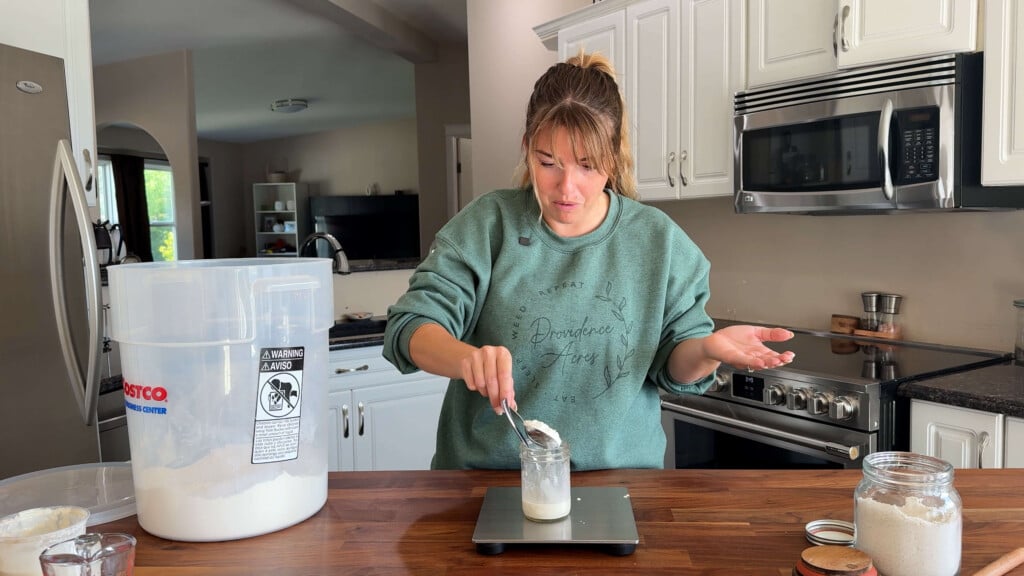 Adding flour to sourdough starter and water, then mixing until fully combined.